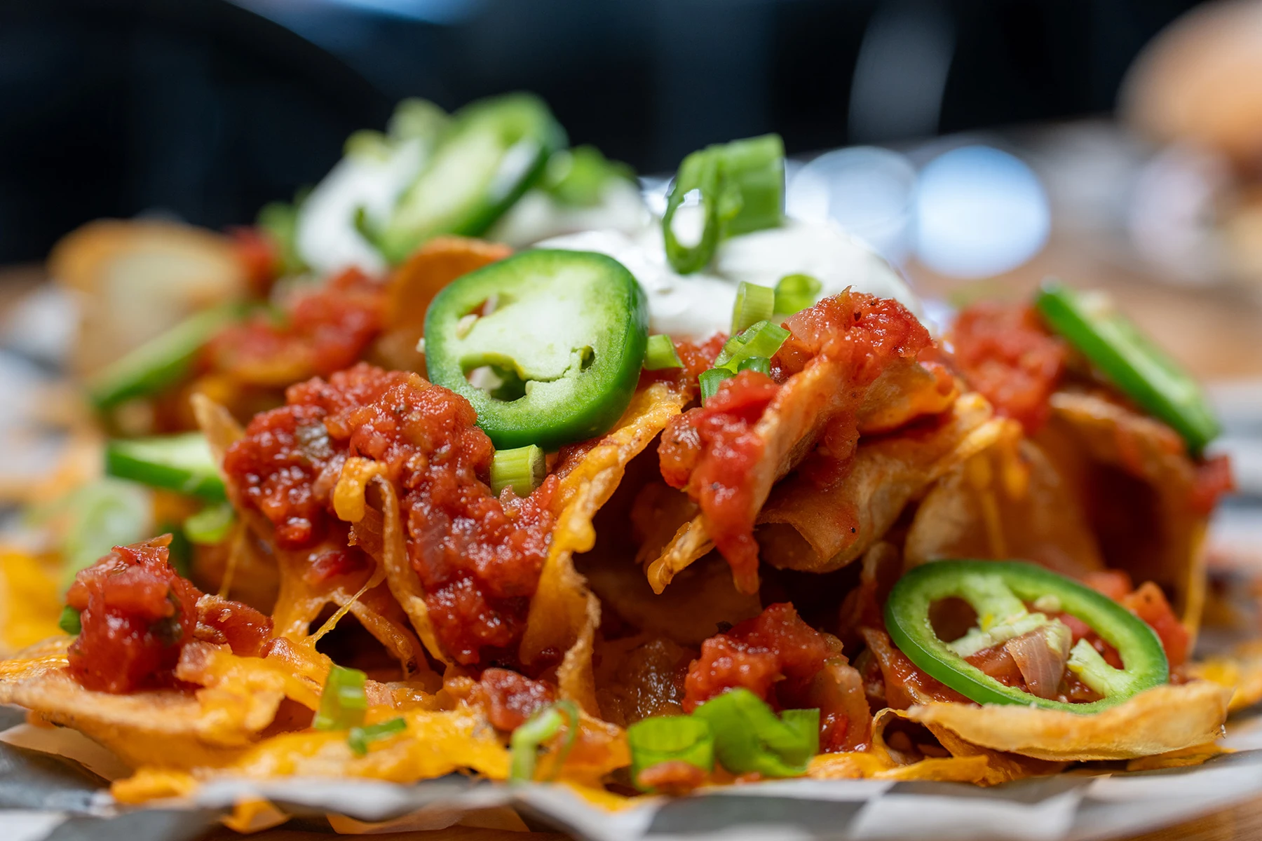 Irish nachos topped with jalapeños, bacon, and sour cream